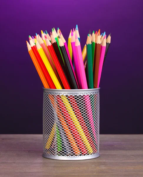 Crayons de couleur en verre sur table en bois sur fond violet — Photo