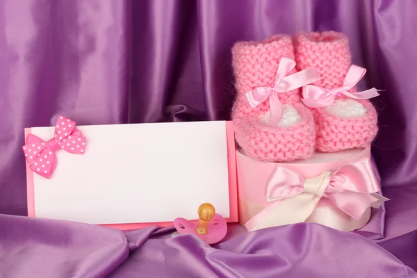 Buty dla dzieci różowy, pacifierd, pocztówka i prezenty na tle jedwab — Zdjęcie stockowe