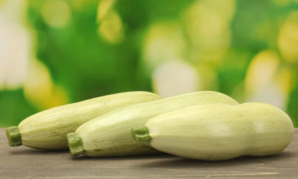 Squash on wooden table on green background close-up — Stock Photo, Image