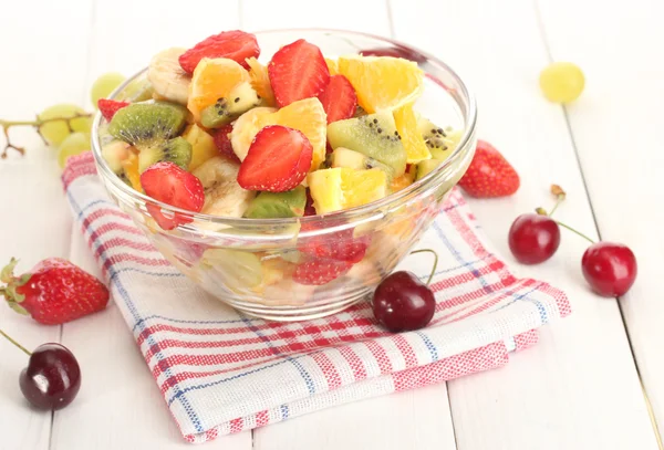 Tazón de cristal con ensalada de frutas frescas y bayas en mesa de madera blanca —  Fotos de Stock