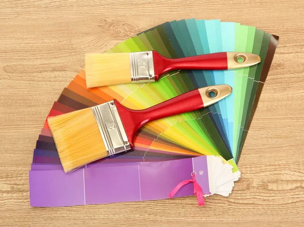 Penslar och ljusa palett av färger på trä bakgrund — Stockfoto
