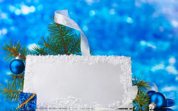 Cartolina bianca, palline di Natale e abete su sfondo blu — Foto Stock