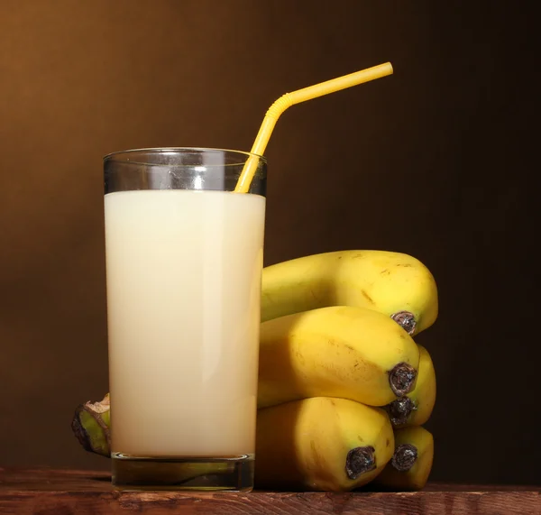 Succo di banana con banane su marrone — Foto Stock