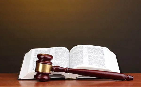 Judge's gavel and open book on wooden table on brown background — Stock Photo, Image