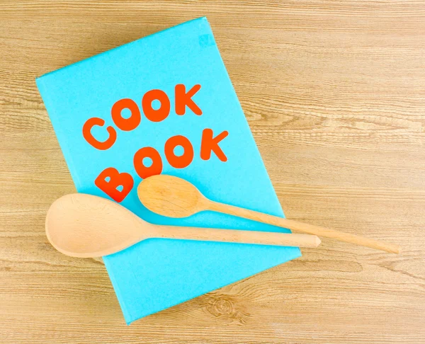 Kuchařka a nádobí na dřevěné pozadí — Stock fotografie