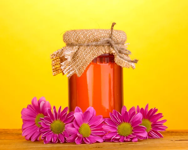 Sweet honey in jar on wooden table on yellow background — Stock Photo, Image