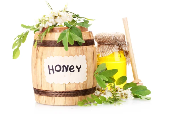 Sladký med v sudu a sklenice s akátovými květy izolované na bílém — Stock fotografie
