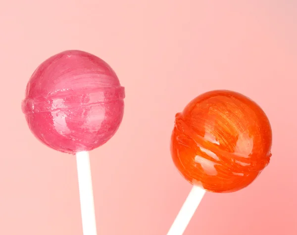 Bright and delicious lollipops on pink background close-up — Stock Photo, Image