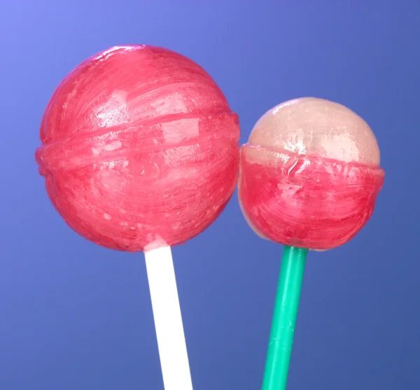 Bright and delicious lollipops on dark blue background close-up — Stock Photo, Image