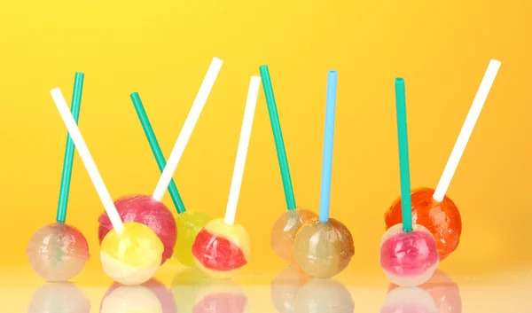 Lollipops brilhantes e deliciosos no fundo amarelo close-up — Fotografia de Stock