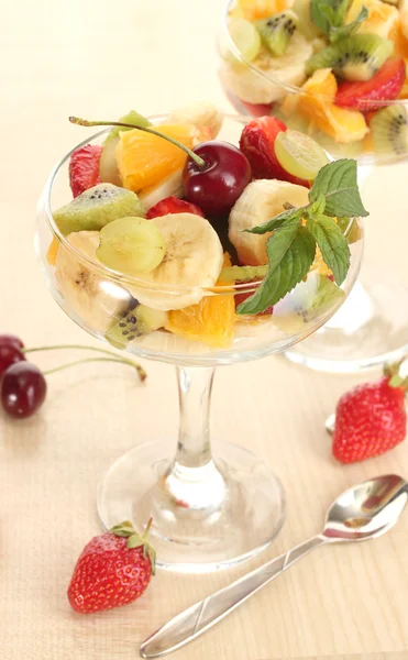 Ensalada de frutas frescas y fresas en mesa de madera —  Fotos de Stock