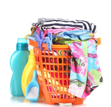 Clothes with detergent and washing powder in orange plastic basket isolated on white clipart