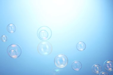 Soap bubbles on blue background clipart