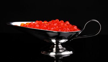 Red caviar in silver bowl isolated on black clipart
