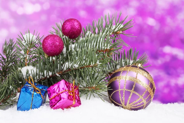Bola de Navidad y juguete con árbol verde en la nieve en púrpura — Foto de Stock