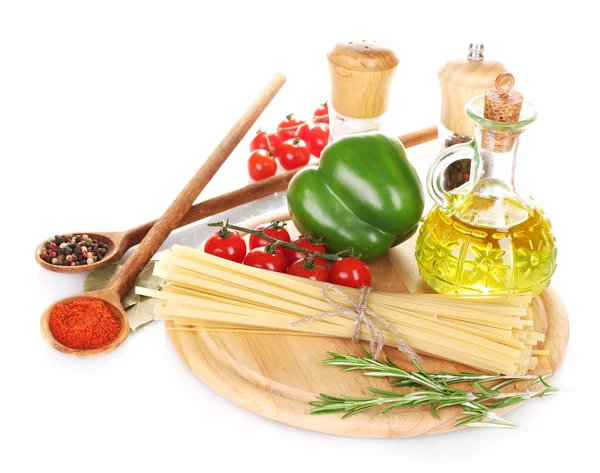 Спагетти, банка с маслом, специи и овощи на деревянной доске изолированы на белом — стоковое фото