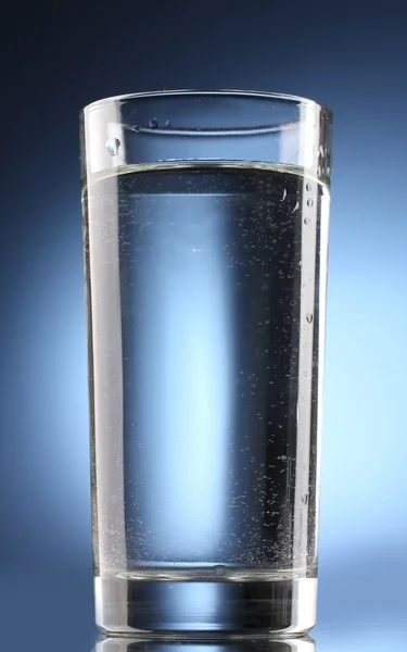 Vaso de agua sobre fondo azul — Foto de Stock