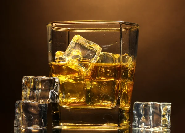 Glas scotch whisky en ijs op bruine achtergrond — Stockfoto