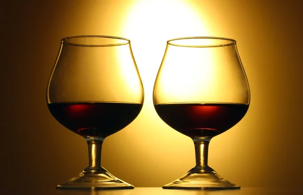 Deux verres de cognac sur fond jaune — Photo