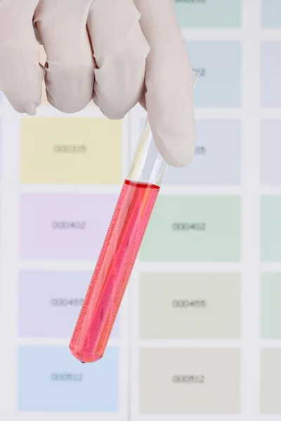 管具有红色液体在手上的颜色样本背景 — 图库照片