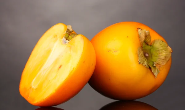 灰色の背景上に食欲をそそる柿 — ストック写真