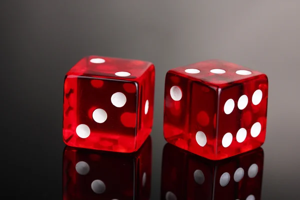 Red dices on grey background — Stock Photo, Image