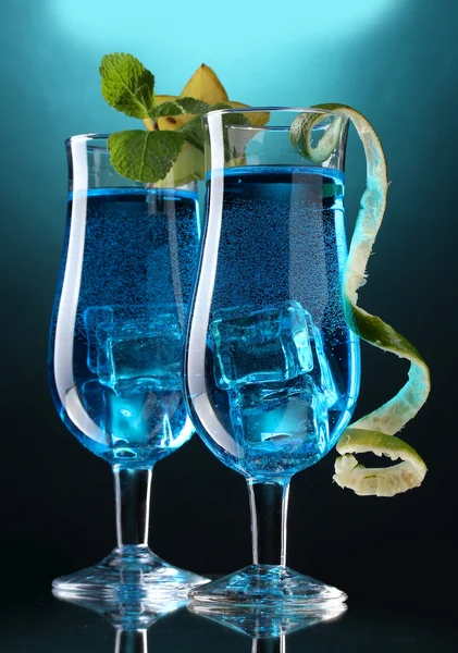 Синий коктейль в очках на синем фоне — стоковое фото