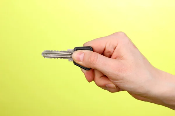 Schlüssel in der Hand auf grünem Hintergrund — Stockfoto