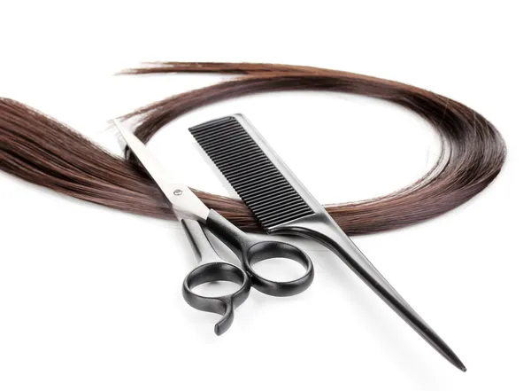 Cabelo castanho brilhante com tesouras de corte de cabelo e pente isolado em branco — Fotografia de Stock
