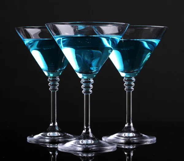 Голубой коктейль в бокалах мартини, изолированных на черном — стоковое фото
