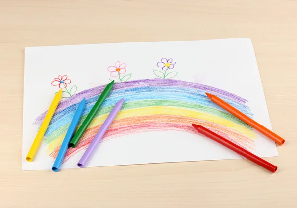 Children's drawing of rainbow and pencils on wooden background — Stock Photo, Image