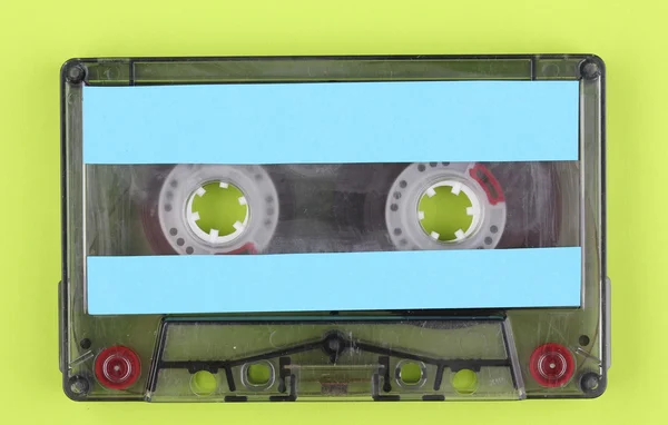 Cassete de áudio com etiqueta colorida em fundo verde — Fotografia de Stock