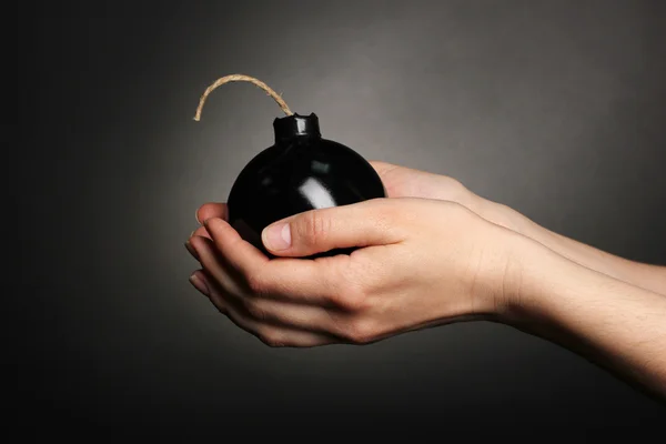 Bomba in stile cartone animato in mano su sfondo nero — Foto Stock