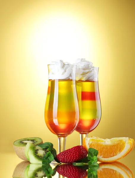 Buah jelly dalam gelas dan buah-buahan pada latar belakang kuning — Stok Foto