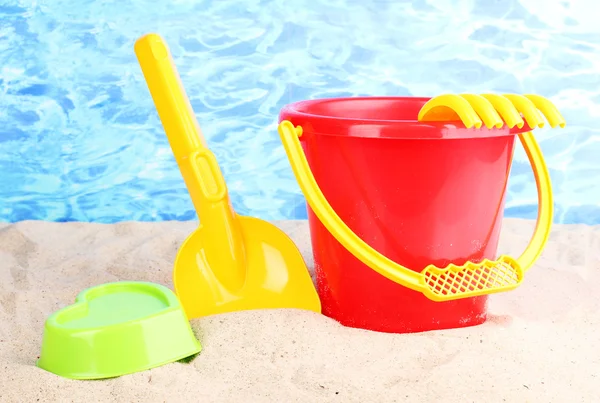 Çocukların plaj oyuncakları kum su arka plan üzerinde — Stok fotoğraf