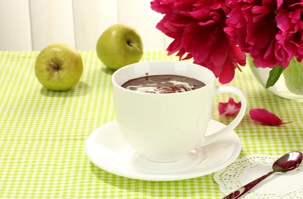Cup hot chocolate, apples and flowers on table in cafe — Stock Photo, Image