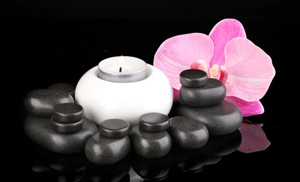 Spa kamienie z orchidea kwiat i świeca na czarnym tle — Zdjęcie stockowe