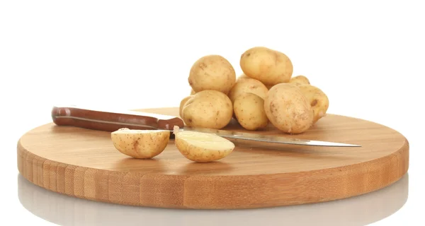 Batatas jovens em uma tábua de corte com faca isolada em branco — Fotografia de Stock