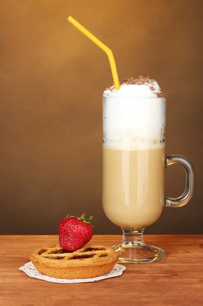 Verre de café cocktail avec tarte sur napperon et fraise sur fond brun — Photo
