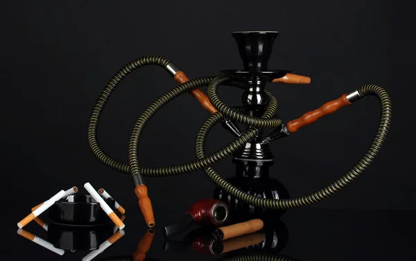 Herramientas para fumar: una cachimba, cigarro, cigarrillo y pipa aislados sobre fondo negro —  Fotos de Stock