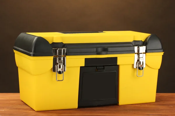 Caixa de ferramenta amarela no fundo marrom close-up — Fotografia de Stock