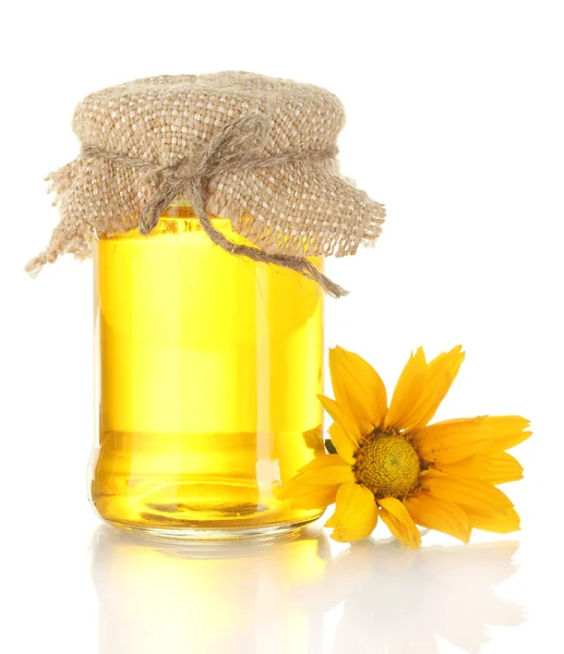 Γλυκό μέλι σε βάζο και λουλούδια που απομονώνονται σε λευκό — Φωτογραφία Αρχείου