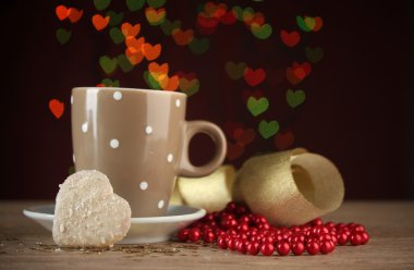 Cup of coffee on wooden table on bright bokeh backdground clipart