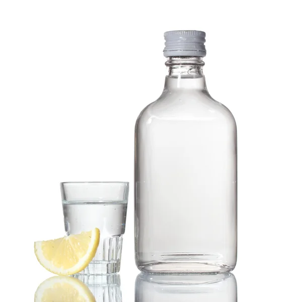 Bottle of vodka and wineglass with lemon isolated on white — Stock Photo, Image