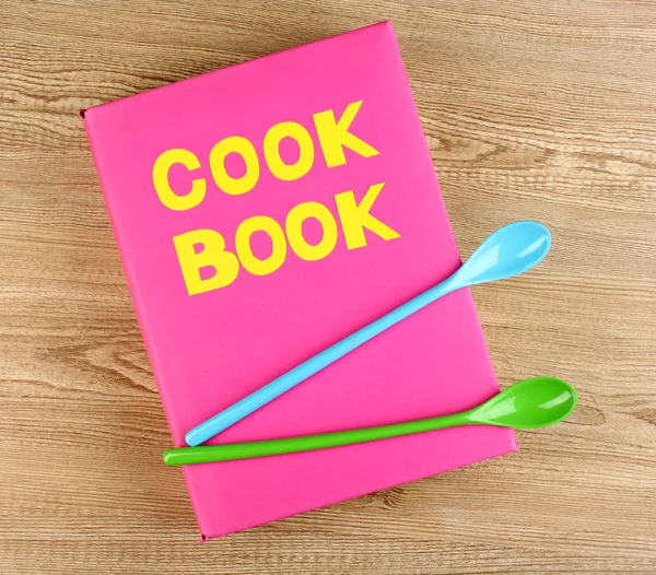 Kookboek en keukengerei op houten achtergrond — Stockfoto