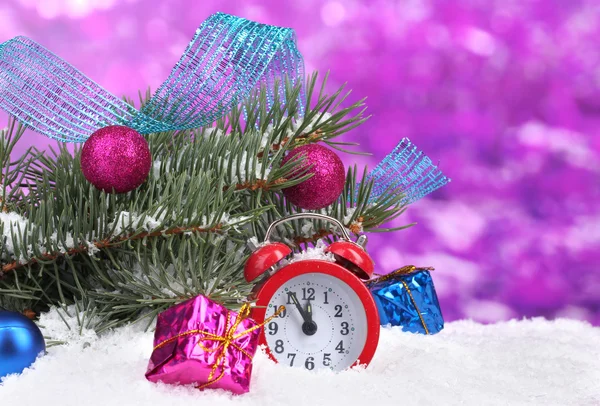 Grüner Weihnachtsbaum mit Spielzeug und Uhr im Schnee auf lila — Stockfoto