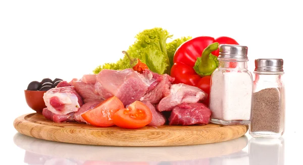 Bitar av rått kött och grönsaker på träplatta isolerad på vit — Stockfoto