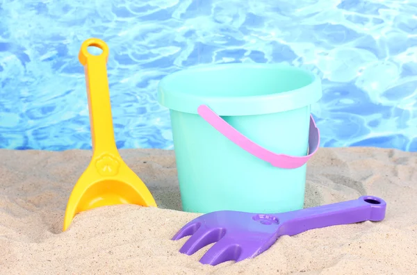 Strand kinderspeelgoed op zand op water achtergrond — Stockfoto