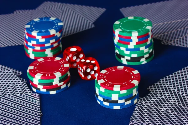 Jugar cartas y dados con las fichas de póquer en una mesa de póquer azul —  Fotos de Stock