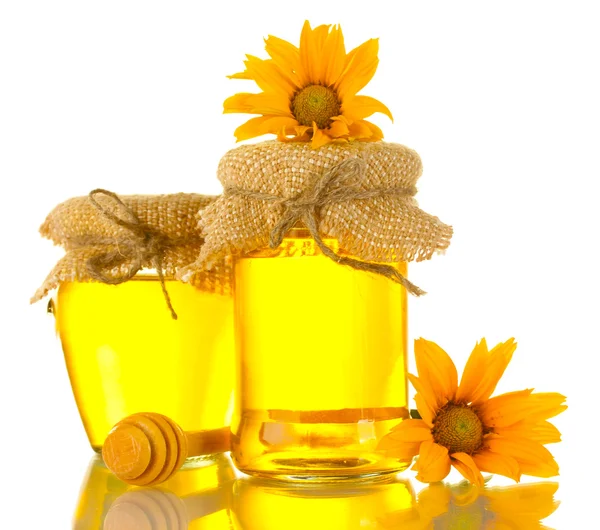 Miel sucré dans des bocaux avec bruine en bois et fleurs isolées sur blanc — Photo